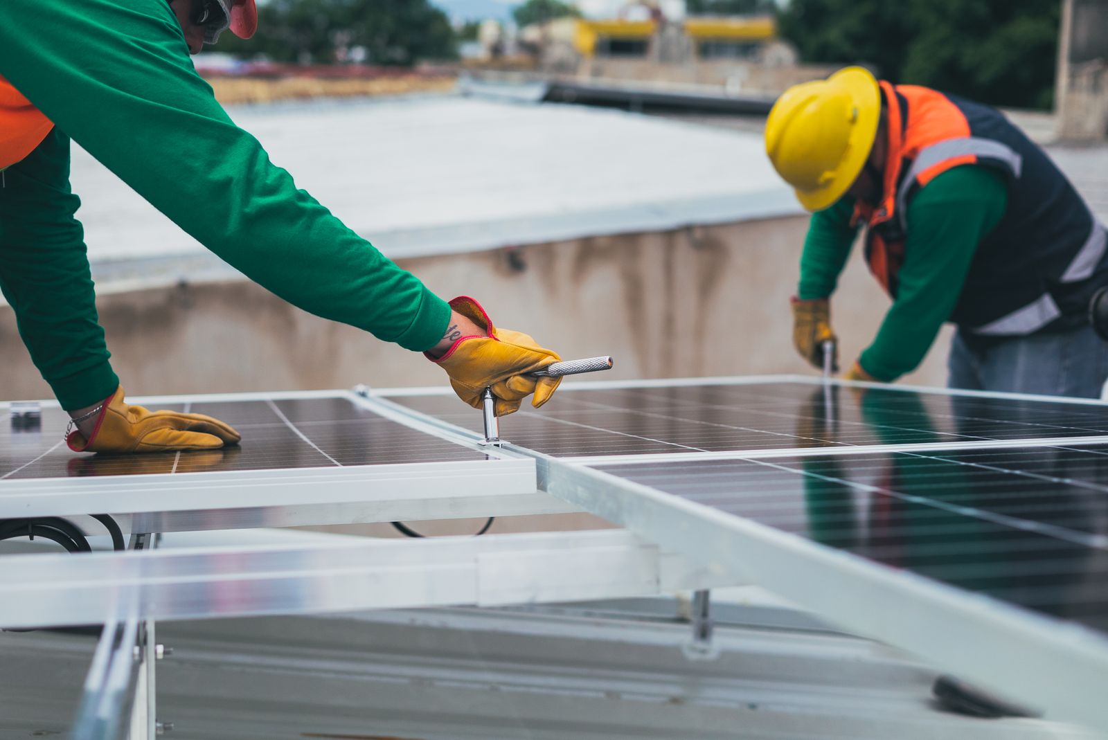 Installers fixing solar panels on a roof